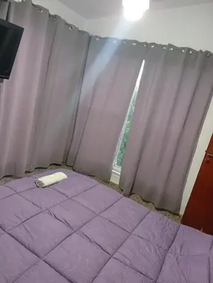 a purple bed in a room with a window at Hotel inti huasi in Villa Carlos Paz