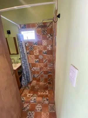 a bathroom with a shower with a tiled floor at La Herminda Casas de Campo in Nono