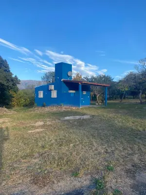 a blue building in the middle of a field at La Herminda Casas de Campo in Nono
