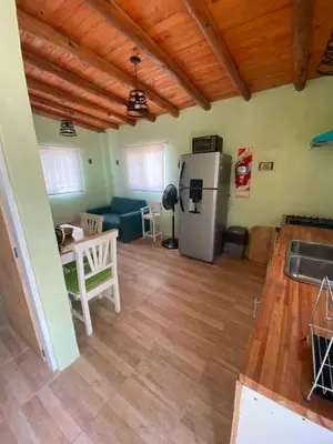 a kitchen and living room with a refrigerator and a table at La Herminda Casas de Campo in Nono