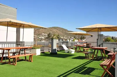 a patio with tables and umbrellas on a roof at DPto Carlos Paz in Villa Carlos Paz