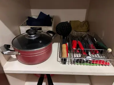 a pot and a basket on a shelf with cooking utensils at DPto Carlos Paz in Villa Carlos Paz