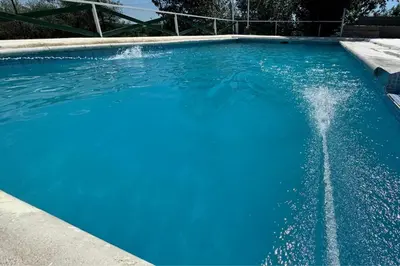 a large blue swimming pool with water in it at Cabañas Antílope & Spa in Tanti