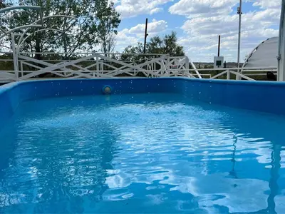 a blue swimming pool with a white fence in the background at Cabañas Antílope & Spa in Tanti