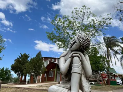 a statue of a woman sitting in a park at Cabañas Antílope & Spa in Tanti