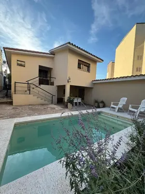 a house with a swimming pool in front of it at El Nogal in Villa Carlos Paz