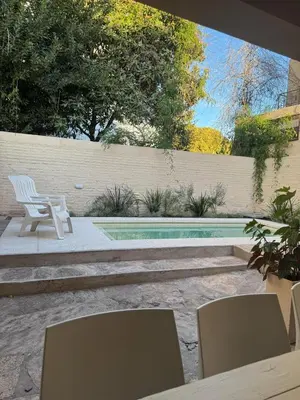 a patio with two chairs and a swimming pool at El Nogal in Villa Carlos Paz