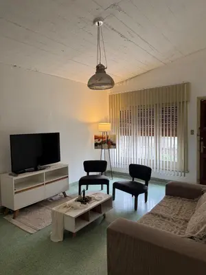 a living room with a couch and a tv at El Nogal in Villa Carlos Paz
