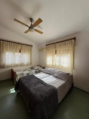 a bedroom with two beds and a ceiling fan at El Nogal in Villa Carlos Paz