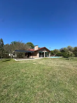 a house with a large yard in front of it at El refugio in Villa del Dique