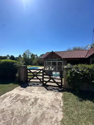 a house with a gate with a sign on it at El refugio in Villa del Dique