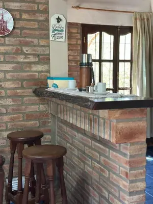 a brick bar with stools in front of a brick wall at El refugio in Villa del Dique