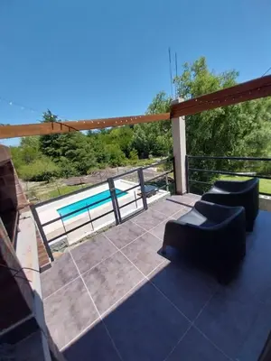 a patio with two couches and a swimming pool at La Morada del Arroyo in Villa Parque Siquiman