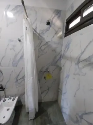 a white bathroom with a sink and a shower at La Morada del Arroyo in Villa Parque Siquiman