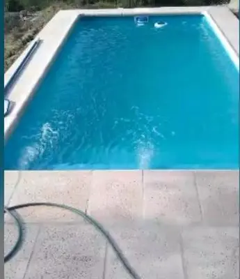 a blue swimming pool with a hose in it at La Morada del Arroyo in Villa Parque Siquiman