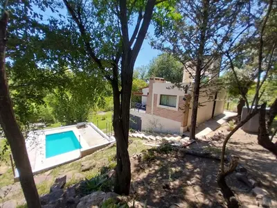 a villa with a swimming pool in the woods at La Morada del Arroyo in Villa Parque Siquiman