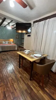 a room with a wooden table and a bed at Terrazas Suite in Potrero de Garay