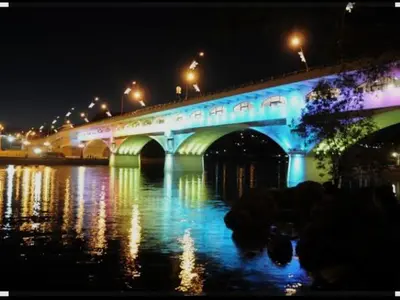a bridge over a river at night with lights at Monoambiente Villa Carlos Paz Centro, Terminal in Cordoba
