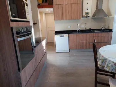 a kitchen with wooden cabinets and a white refrigerator at Casa en Villa General Belgrano in Villa General Belgrano