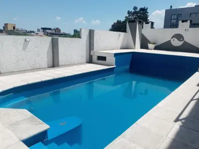a blue swimming pool on the roof of a building at Departamanto 1 dormitorio Carlos Paz Tupungato in Villa Carlos Paz