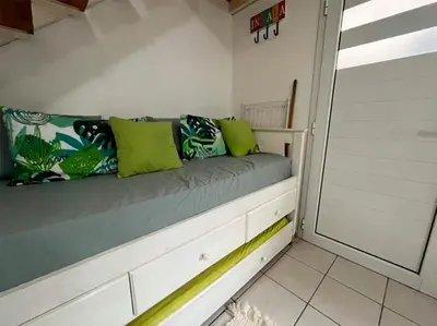 a bench in a room with green pillows on it at Departamanto 1 dormitorio Carlos Paz Tupungato in Villa Carlos Paz