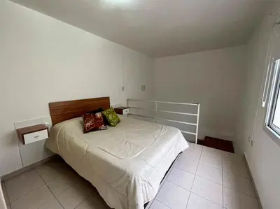a bedroom with a bed in a white room at Departamanto 1 dormitorio Carlos Paz Tupungato in Villa Carlos Paz