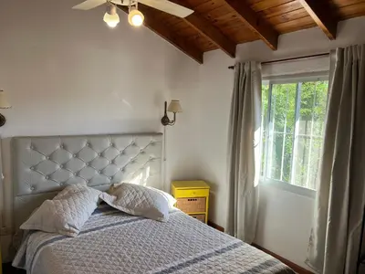 a bedroom with a bed with a ceiling fan and a window at La mejor vista in Villa General Belgrano