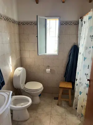 a bathroom with a toilet and a sink and a window at La mejor vista in Villa General Belgrano