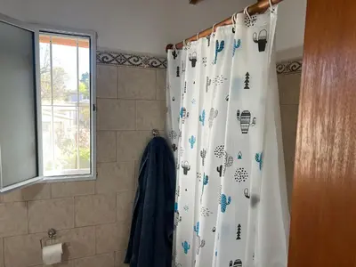 a shower curtain in a bathroom with a window at La mejor vista in Villa General Belgrano