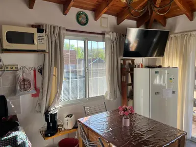 a kitchen with a refrigerator and a table and a window at La mejor vista in Villa General Belgrano