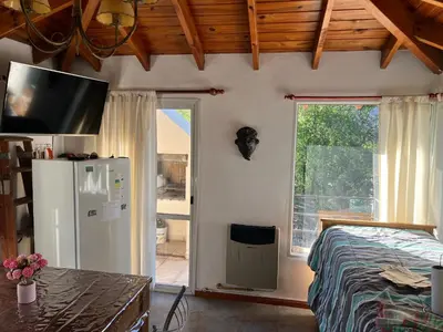a bedroom with a bed and a tv on the wall at La mejor vista in Villa General Belgrano
