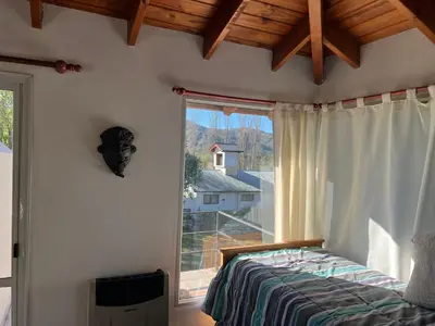 a bedroom with a bed and a large window at La mejor vista in Villa General Belgrano