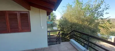 a balcony of a house with a bench and a tree at Cabaña Cerca del rio Cabalango in Cavalango