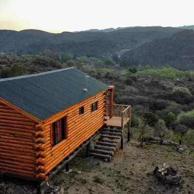 a log cabin with solar panels on the roof at Piedras Blancas in La Bajada