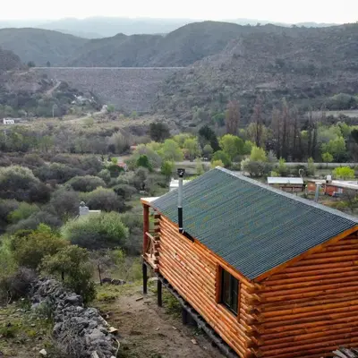 a log cabin with a green roof on a mountain at Piedras Blancas in La Bajada