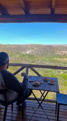a man sitting at a table on a porch at Piedras Blancas in La Bajada