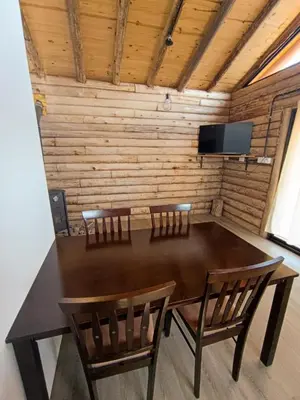 a dining room table with two chairs and a television at Piedras Blancas in La Bajada