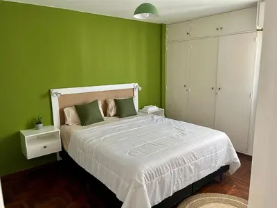 a bedroom with green walls and a white bed at Dulce de Córdoba in Cordoba