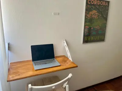a laptop computer sitting on a wooden desk on a wall at Dulce de Córdoba in Cordoba