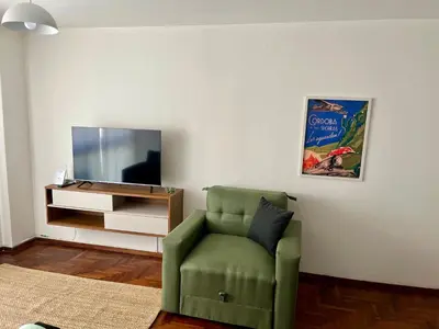 a living room with a green chair and a tv at Dulce de Córdoba in Cordoba