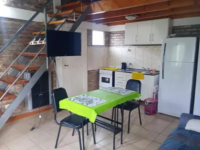 a kitchen with a table and chairs and a refrigerator at El Cardal II in Río Cuarto