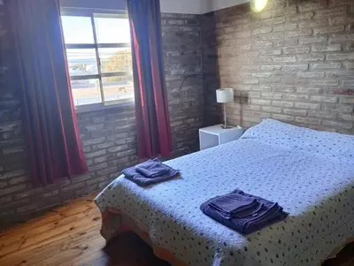 a bedroom with a bed with blue towels on it at El Cardal II in Río Cuarto