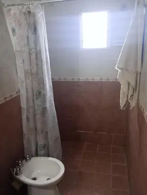 a bathroom with a toilet and a shower with a window at El Cardal II in Río Cuarto