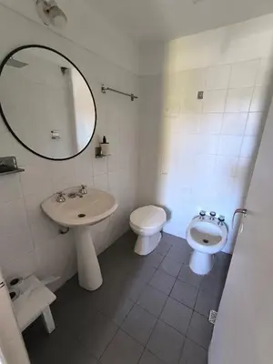 a bathroom with a sink and a toilet and a mirror at Casa Milu in Mina Clavero