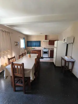 a kitchen with a table and chairs and a refrigerator at Casa Milu in Mina Clavero