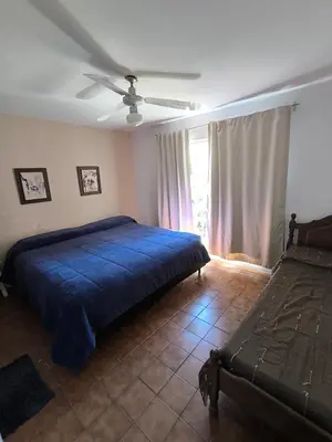 a bedroom with a blue bed and a window at Casa Milu in Mina Clavero