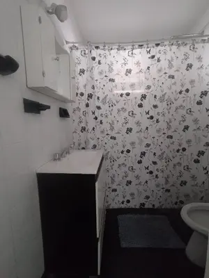 a bathroom with a shower curtain with a sink at Casa Milu in Mina Clavero
