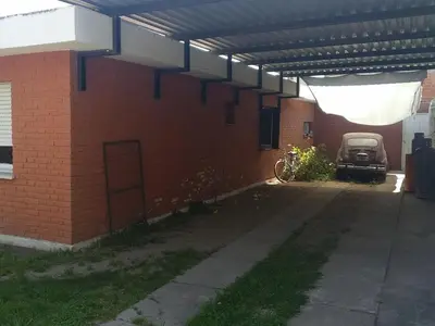 a brick building with a car parked under a roof at Casa Milu in Mina Clavero