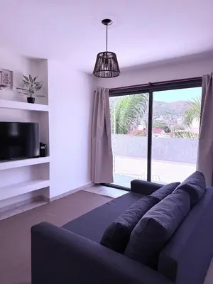 a living room with a couch and a large window at Puntasol vcpaz in Villa Carlos Paz