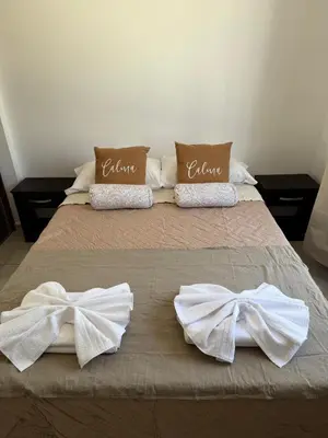 a bed with white towels and bows on it at Puntasol vcpaz in Villa Carlos Paz